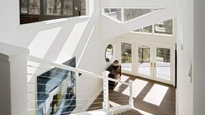 A modern interior with a staircase leading to a balcony.