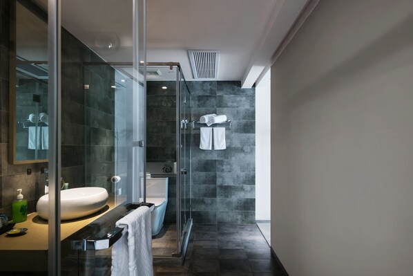 A modern bathroom with a glass shower enclosure, a white sink, and a bathtub. - Floral Hotel Hangzhou Yunqi Fanjinglan (Hangzhou)