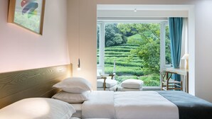 A hotel room with a large window, a bed, a desk, and a chair. - Floral Hotel Hangzhou Yunqi Fanjinglan (Hangzhou)