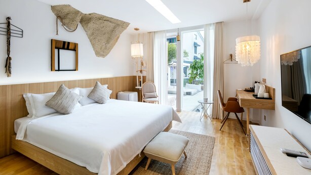 A hotel room with a large bed, a desk, a television, and a view of the outdoors. - Floral Hotel Hangzhou Lvpin Designer (Hangzhou)
