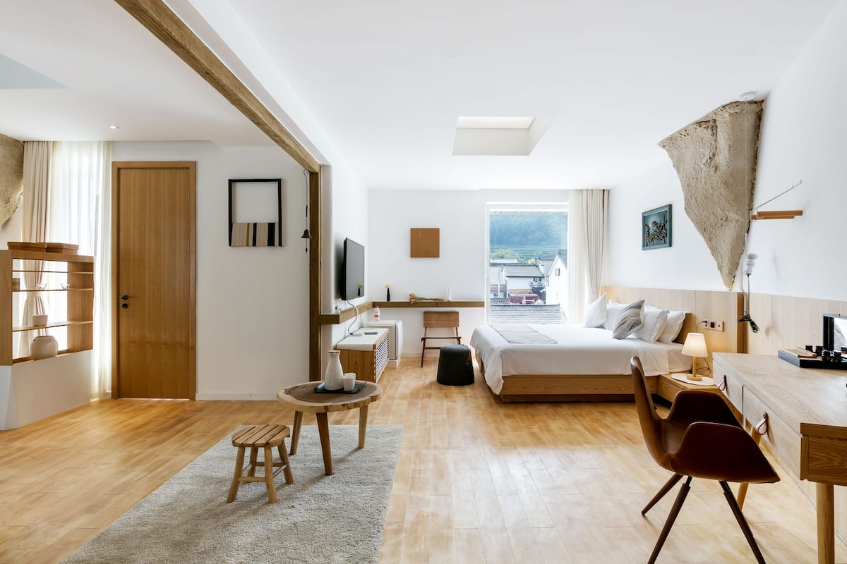 Une chambre d’hôtel moderne équipée d’un lit, d’un bureau, d’une chaise et offrant une vue sur la ville.