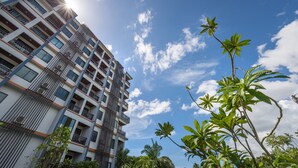 A multi-story building with balconies and air conditioning units, surrounded by greenery. - Andaman Breeze Resort - (Krabi)