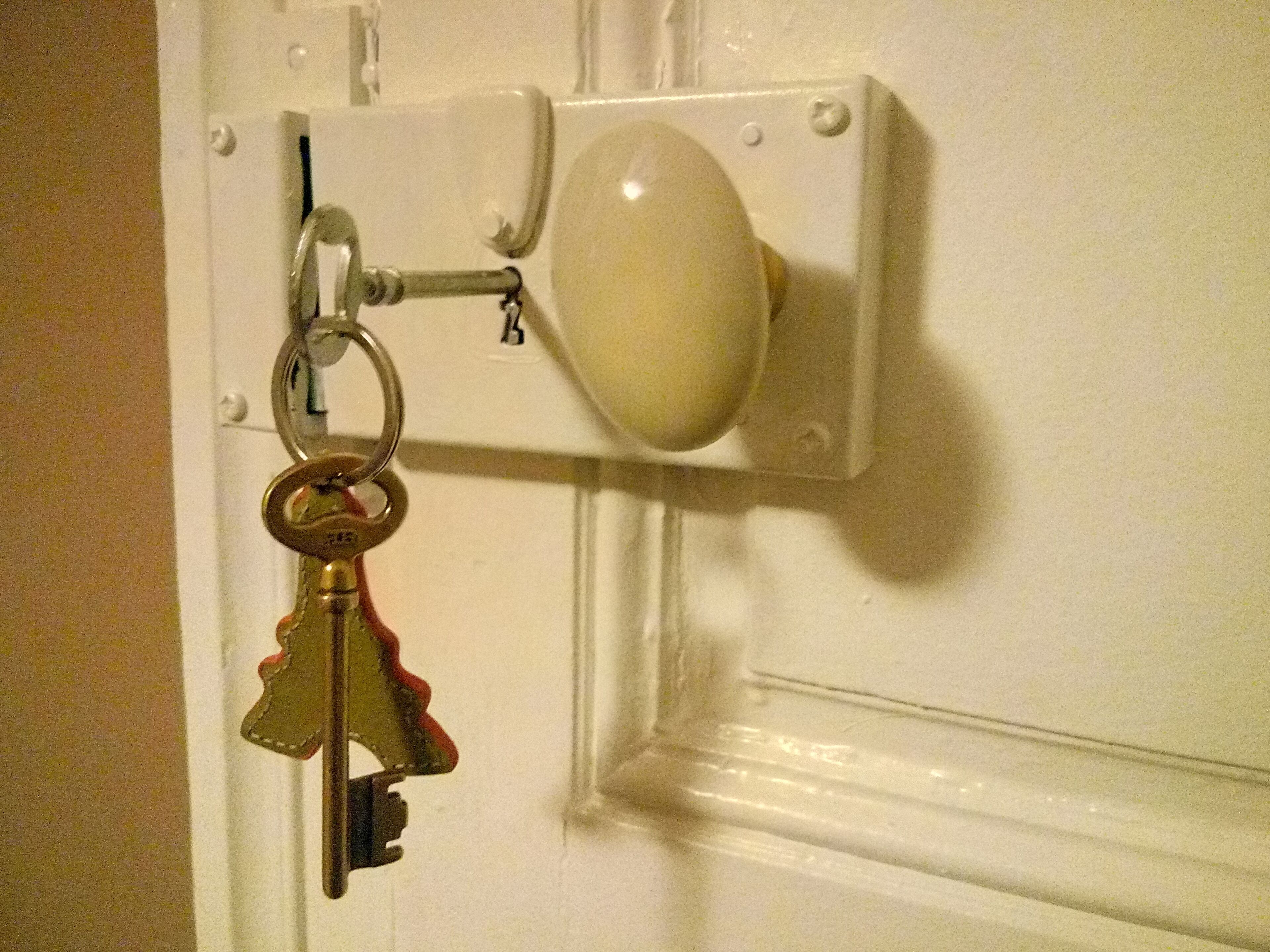A door with a key lock and a keychain.