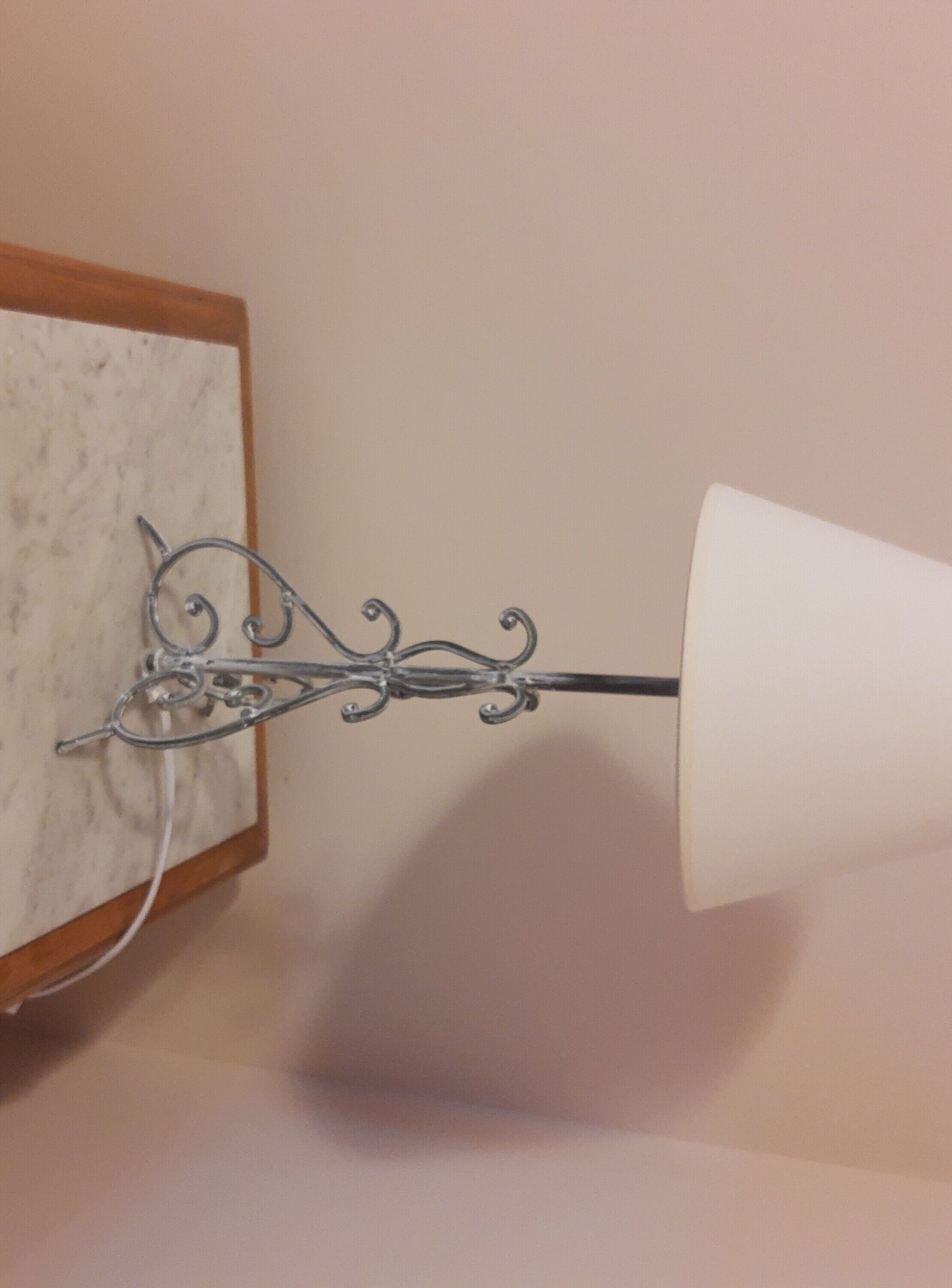 Luminária de parede em metal com cúpula branca.