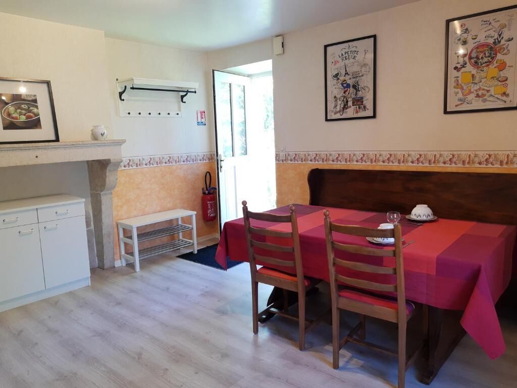 Un coin repas avec une table dressée pour deux personnes, un banc et un extincteur fixé au mur.