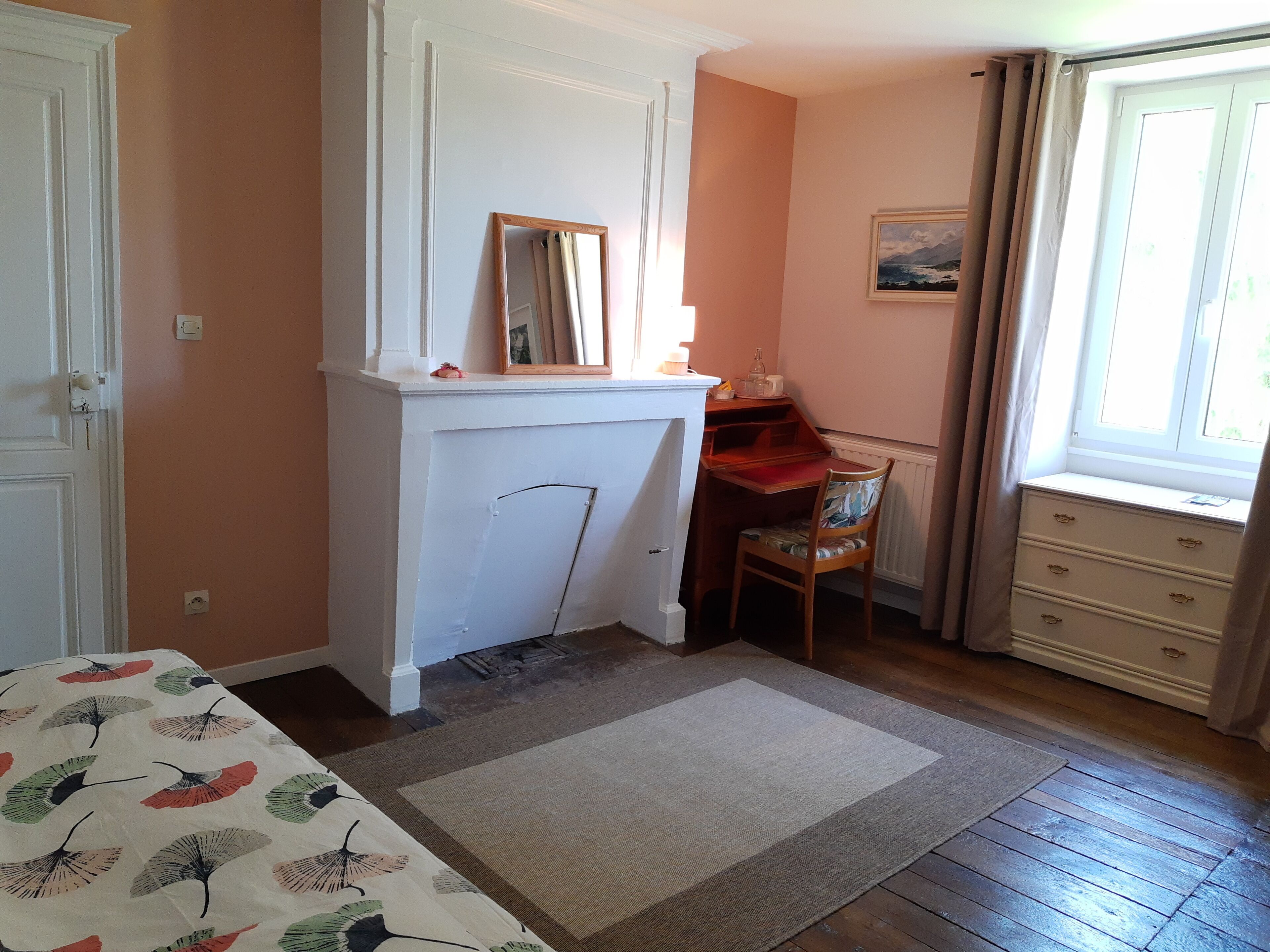 Un dormitorio con cama, escritorio, silla, cómoda, ventana y puerta.
