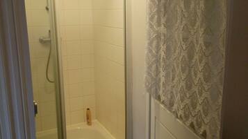 A bathroom with a shower, a bathtub, and a towel hanging on the wall.