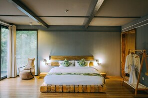 A modern bedroom with a wooden headboard, a large bed with white bedding, a wooden chair, and a wooden floor. - Floral Hotel Moganshan Cuiyu Resort (Huzhou)