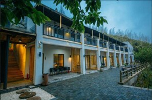 A modern building with a covered outdoor area, a staircase, and a paved walkway. - Floral Hotel Moganshan Cuiyu Resort (Huzhou)