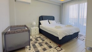 Ein modernes Schlafzimmer mit Bett, Nachttisch, Lampe, Klimaanlage und einem gemusterten Teppich.