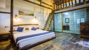 A room with a large bed, wooden beams, a painting on the wall, and a staircase leading to an upper level. - Floral Hotel Moganshan Yaozhuang (Huzhou)