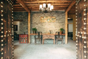 A rustic interior with exposed brick walls, wooden beams, and a wooden dining table with chairs. - Floral Hotel Moganshan Yaozhuang (Huzhou)