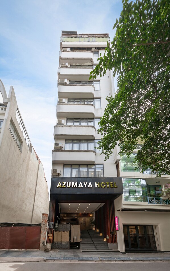 Un hotel de varios pisos con una entrada destacada y señalización.