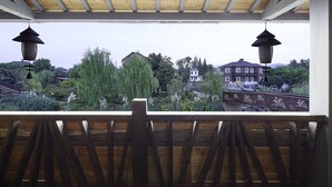Ein Holzbalkon mit Blick auf ein Wohngebiet, einschließlich Häuser und Bäume.