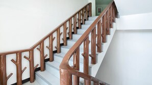 A staircase with wooden railings and a white wall. - OYO 195 Ranchotel - Binan (Biñan City)