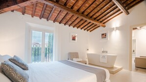 A bedroom with a large bed, a bathroom with a bathtub, and a balcony with a view. - Palazzo Cini Luxury Rooms In Pisa (Pisa)