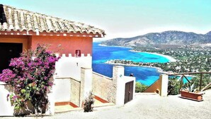 A coastal building with a view of the sea and mountains.