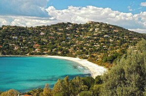 Une ville côtière avec des maisons construites sur une colline, d’où l’on a vue sur une plage.