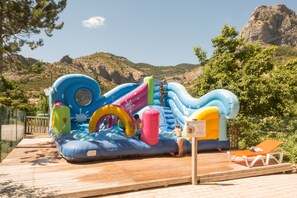 Una piscina al aire libre, sombrillas, sillones reclinables de piscina