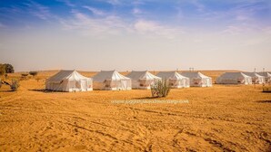 A row of white tents in a desert setting.