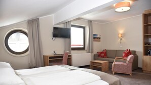 A hotel room with a bed, a desk, a sofa, and a TV. - Hotel Skischule Krallinger (Tweng)