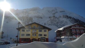A hotel with a yellow facade, a sign reading "Gamsbieten," and a mountain backdrop. - Hotel Skischule Krallinger (Tweng)