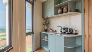 Una cocina con un amplio ventanal, armarios azul claro y suelo de madera en patrón de espiga.