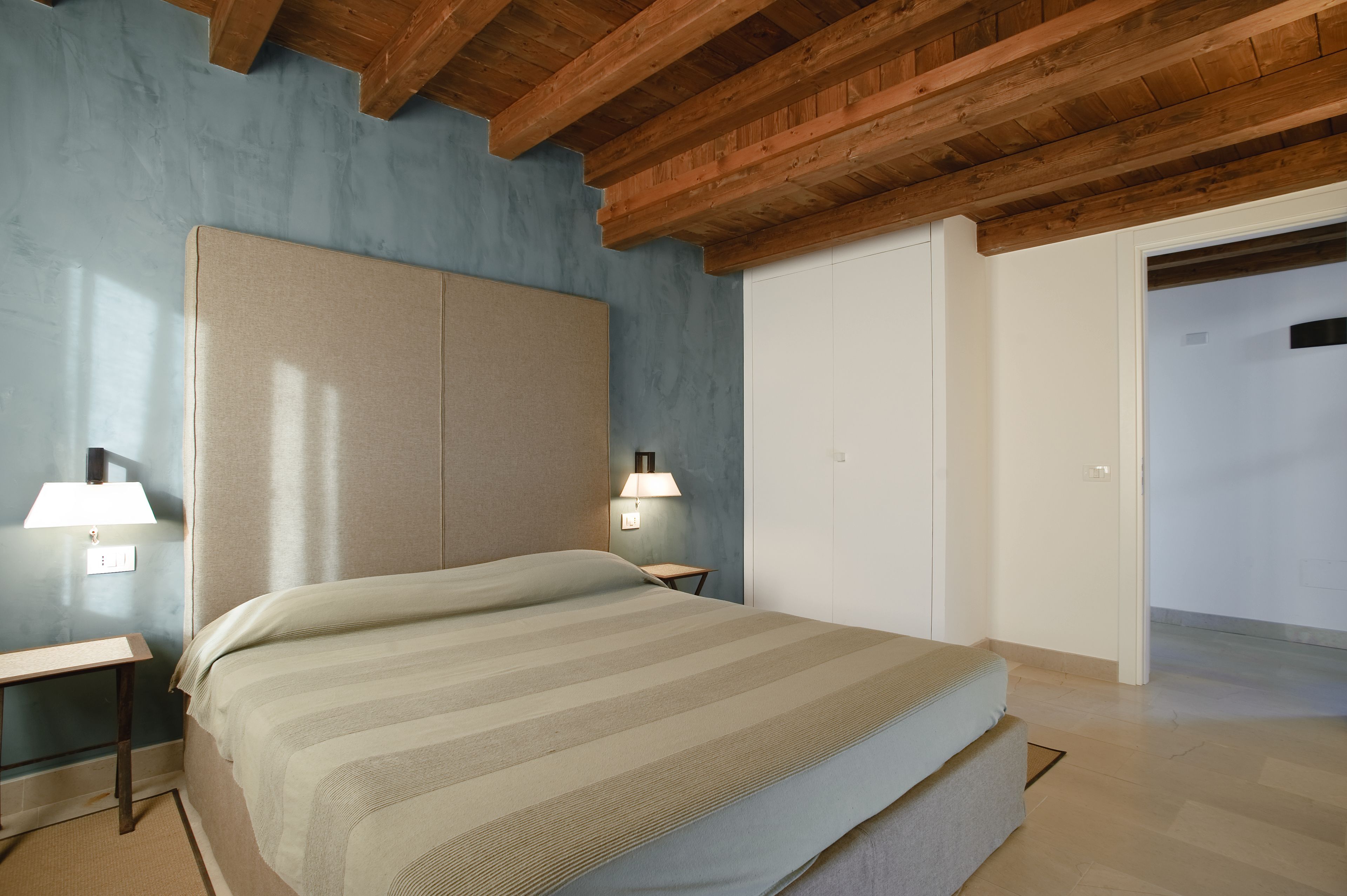 Une chambre à coucher avec un lit, des tables de chevet et un plafond en bois.