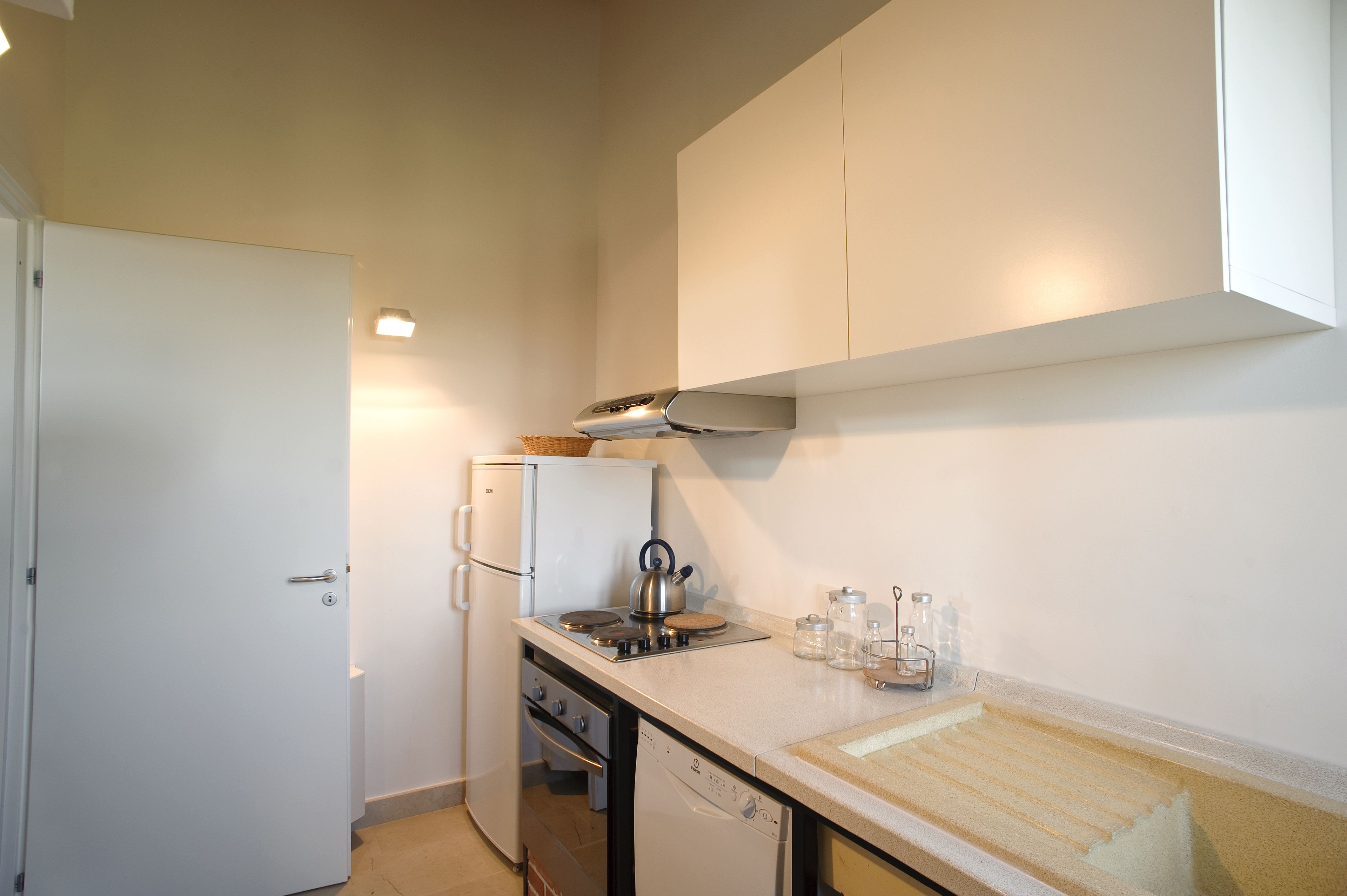 Una cocina compacta con refrigerador, estufa y lavavajillas.