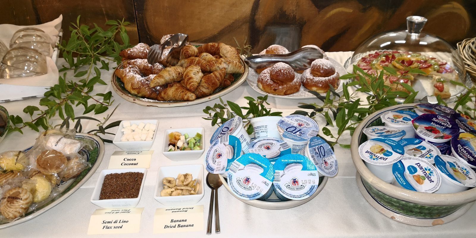 A buffet table with various food items including pastries, fruits, and dairy products.