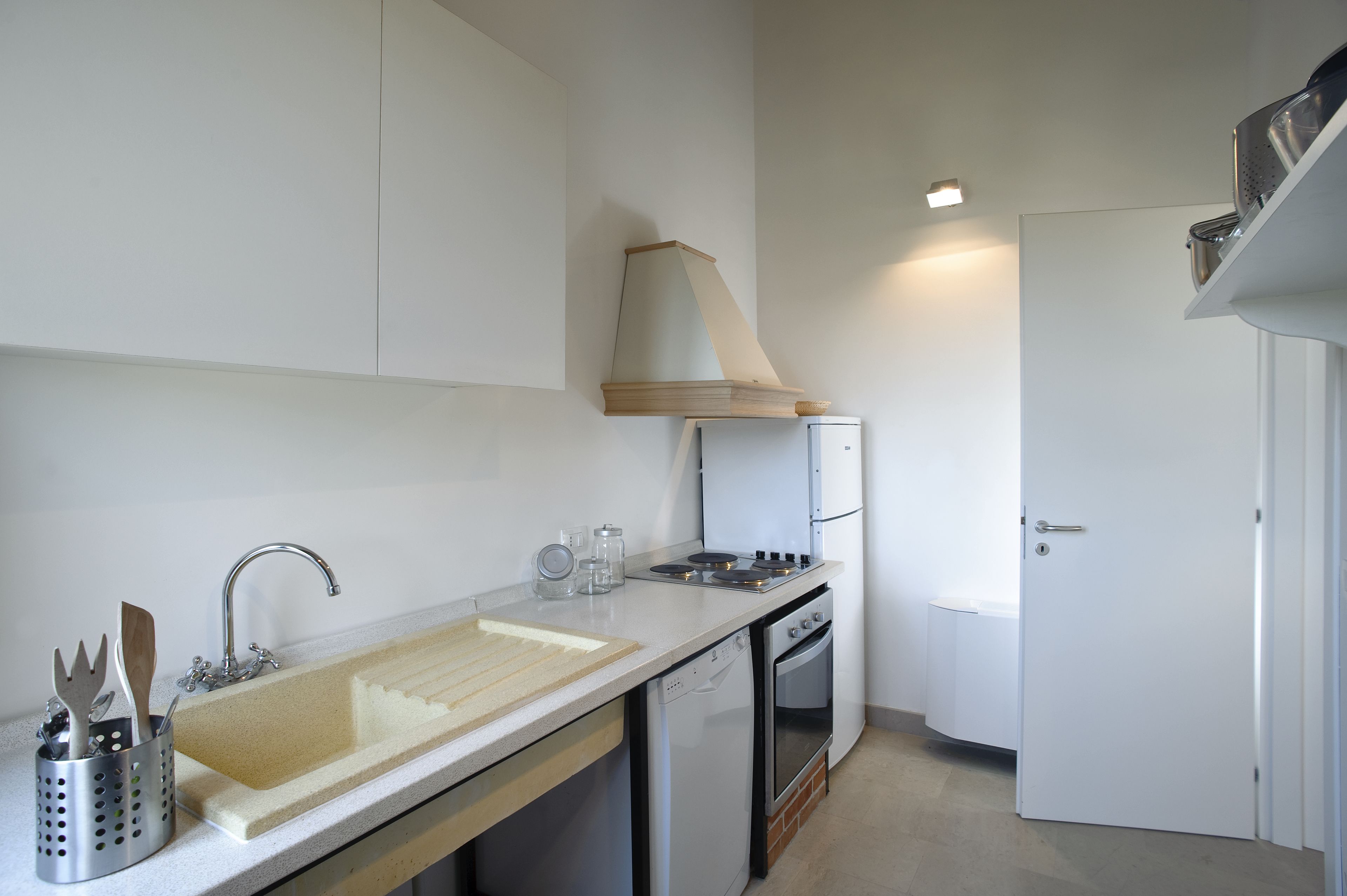 Una cocina compacta con pileta, estufa y horno.