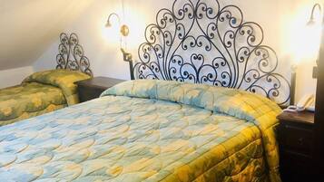 A bedroom with a bed, a nightstand, and a wall-mounted light fixture.