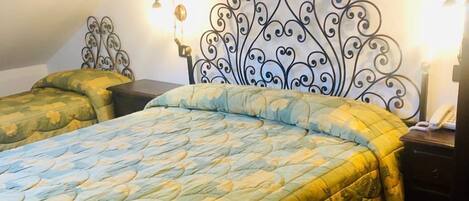 Un dormitorio con cama, mesita de noche y lámpara de pared.