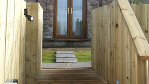 A stone building with a wooden entrance and two windows. - Garth Cottage (Brampton)