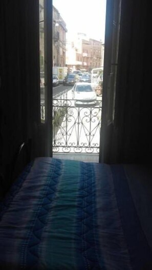 A room with a bed and a view of a street through an open window. - Bed and Breakfast Priscilla (Regalbuto)