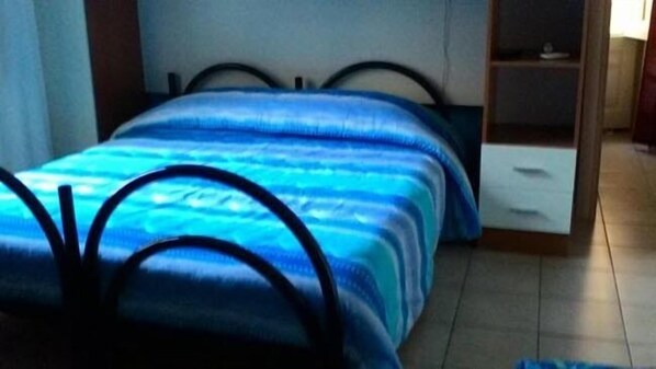 A bedroom with a bed, a nightstand, and a wardrobe. - Bed and Breakfast Priscilla (Regalbuto)