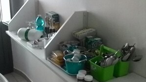 A kitchen area with a white countertop, various kitchen utensils, and containers. - Bed and Breakfast Priscilla (Regalbuto)