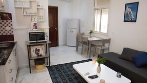 A compact living space with a kitchenette, a dining area, and a sofa. - Charmin & Trendy Apartment Marsa Beach (La Marsa)