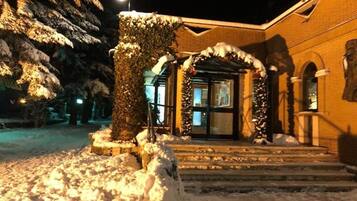 Un edificio con un ingresso e delle scale coperte di neve.