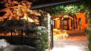 A stone building with a sign reading "Picchio" and a snow-covered entrance. - LH Hotel il Picchio (Pescasseroli)
