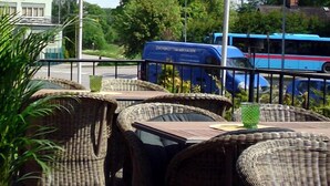 Wicker furniture and a blue bus in the background. - Vingåkers Hotell (Vingåker)