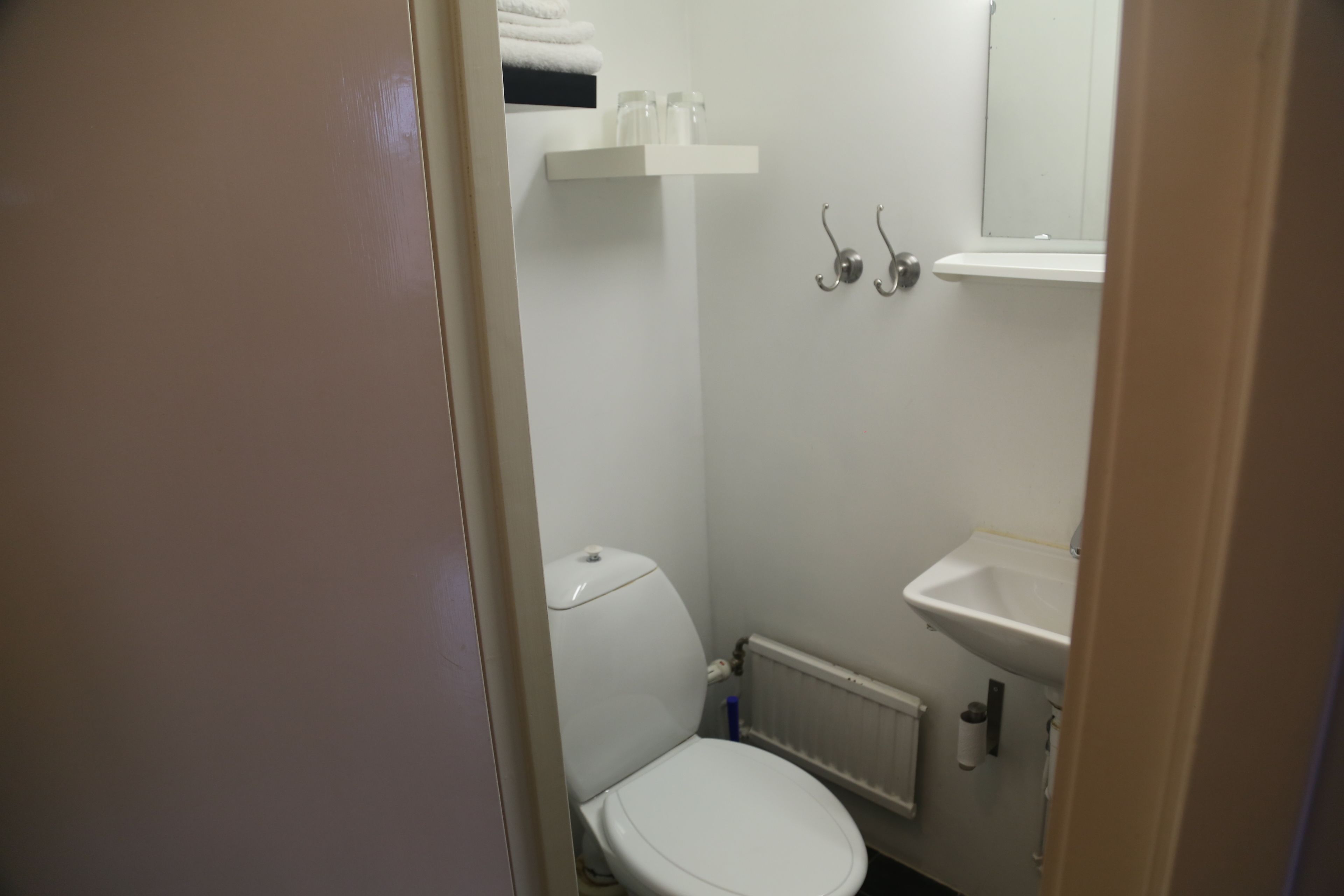 A small, clean bathroom with a toilet, sink, and towel rack.