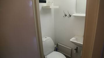 A small, clean bathroom with a toilet, sink, and towel rack.