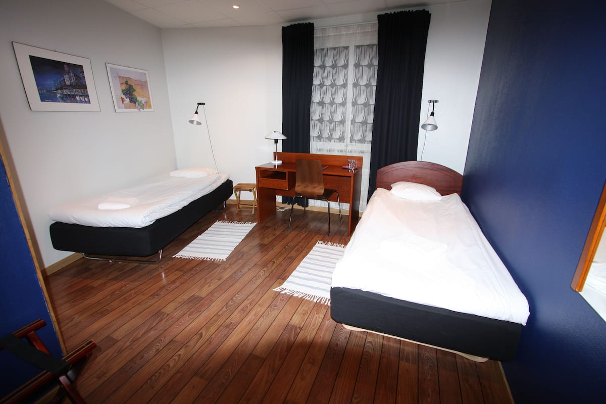 Twin Room (Shared Bathroom) | Desk, laptop workspace, blackout drapes, iron/ironing board