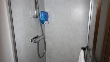 Ett litet, avskilt duschutrymme med ett duschhuvud som kan hållas i handen, ett duschmunstycke som kan användas som handdusch och en blå tvålbehållare.