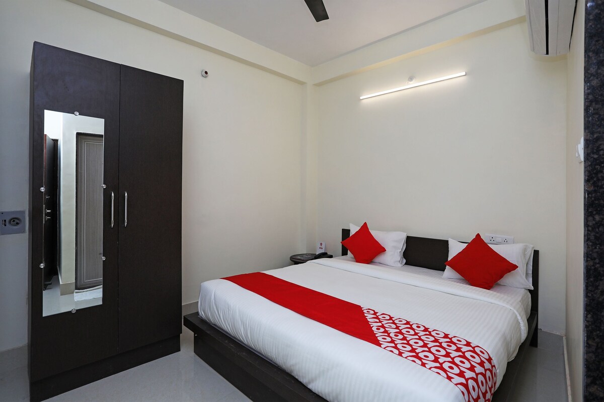 A hotel room with a large bed, a wardrobe, a bedside table, and a nightstand.