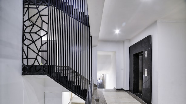 A modern interior with a staircase, a black metal railing, and a door.