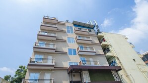 Un edificio residencial de varios pisos con balcones, ventanas y cielo despejado.
