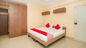 A bedroom with a bed, wooden wardrobe, and a door.
