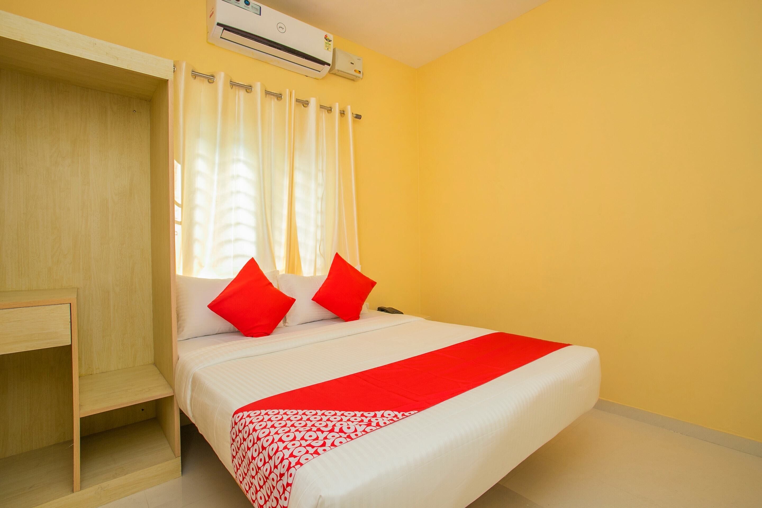 Een kamer met een bed, een bureau en een airconditioning.